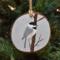 A handmade wood slice Christmas ornament with an acrylic painting of a chickadee in the snow at Cove Creek Photography.